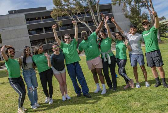 students in matching green shirts high-fiving