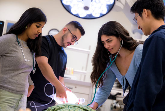 medical students working with a mannequin patient